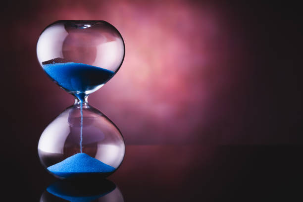 istock blue sand hourglass on old background 1221683769