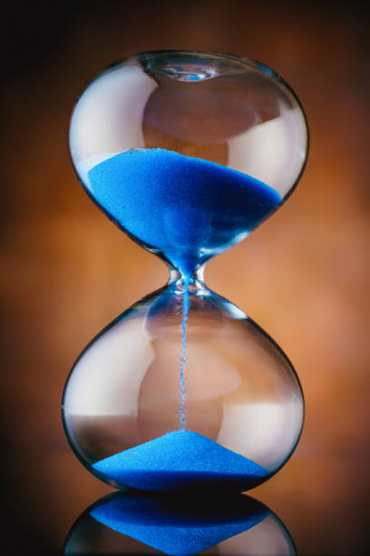 istock blue sand hourglass on old background 1221684082