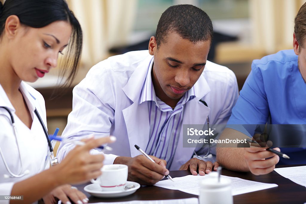 Young african doctor making notes Young african-american doctor making notes at the medical meeting Medical Student Stock Photo