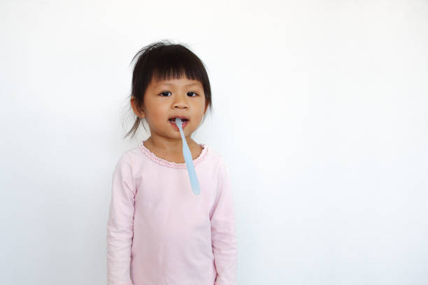 istock funny asian kid bites toothbrush 1221686245