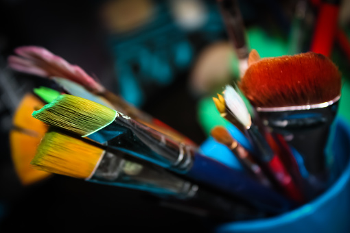 Full Frame of colourful Paint brushes placed in blue cup