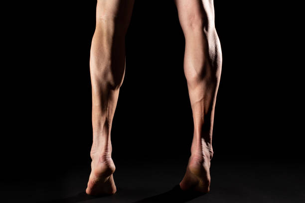 黒い背景を持つ筋肉の脚 - back rear view men muscular build ストックフォトと画像