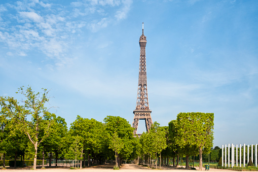 Eiffel Tower and Champ de Mars are empty during pandemic Covid 19 in Europe. There are no people, no tourists because people must stay at home and be confine. Schools, restaurants, stores, museums... are closed. In the foreground, there is the \