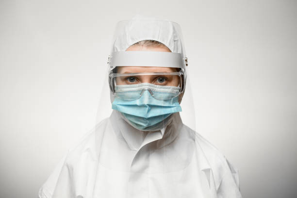 istock woman scientist in protective suit with shield and medical mask. 1221690384