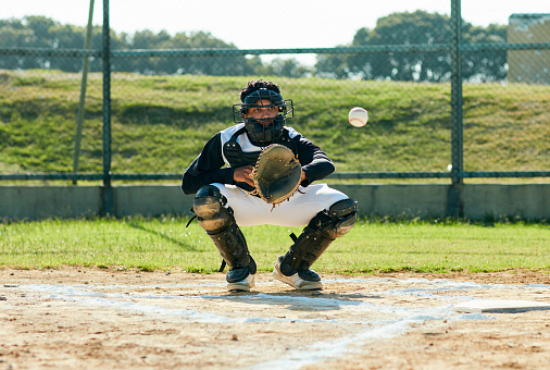 Full length shot of a handsome young baseball player catching a ball during a game on the field