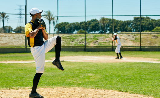 Full length shot of a handsome young baseball player pitching a ball during a match on the field