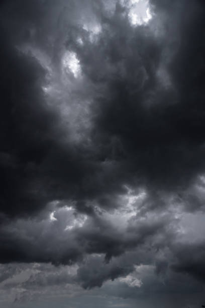 istock Terrible thunderclouds from the side of a plane. Gloomy epic clouds. Background image in a dark gray style. 1221693365