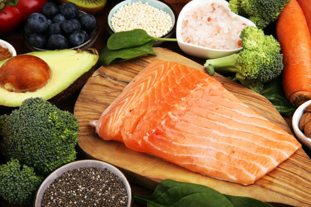 istock Healthy food clean eating selection: fish, fruit, vegetable, cereal, leaf vegetable on rustic background 1221693793
