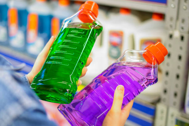 young adult woman choosing bottle of detergent during quarantine with mask stock photo