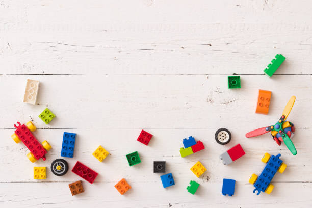istock Above view on different small toy bricks, details, parts on white wooden table background 1221695078