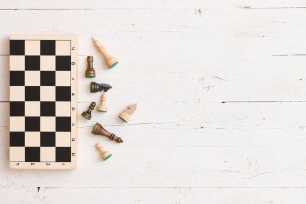istock Top view on wooden chess board and chess figures on white wooden table background 1221695175