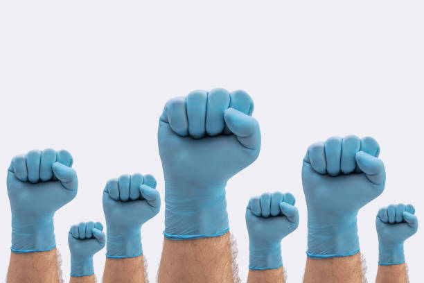 istock Fists Hands in medical blue latex protective gloves on white background 1221695210