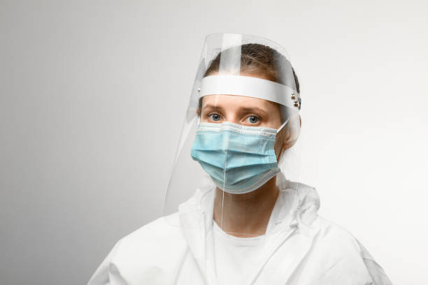 young woman in medical mask and protective shield on her head