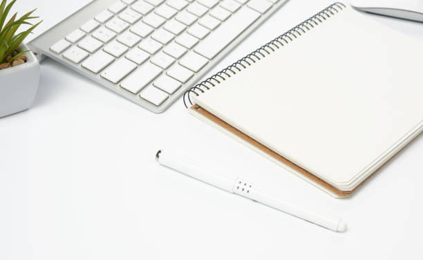 istock open paper notebooks and pen, computer mouse and green plants in 1221697486