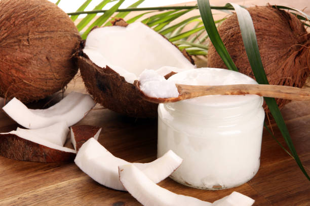 istock Coconut oil with fresh nut and palm leaves on rustic background. 1221698482