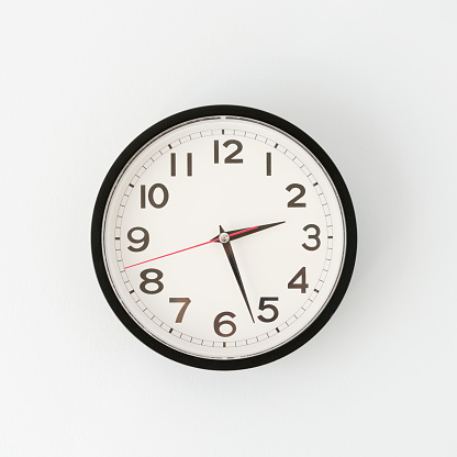 Part of analogue plain wall clock on white wall background. Four o'clock twelve minutes. Close up with copy space, timing, time management, opening hours time, school concept and lunch time