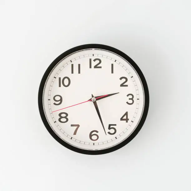 Photo of Round metal clock on white wall