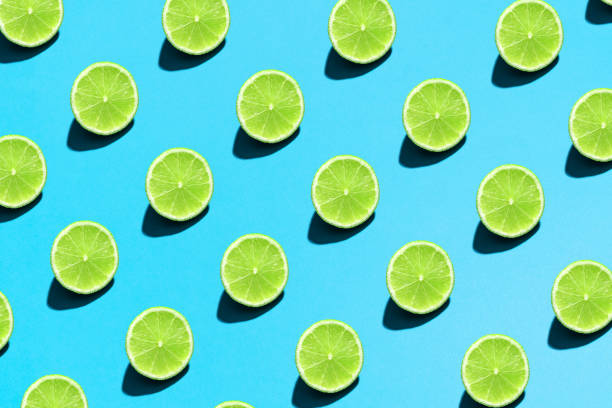 istock Lime pattern on bright light blue background. Minimal flat lay food texture. Summer abstract trendy fresh concept 1221700894