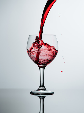 Glass of red wine, with stain, isolated on white.