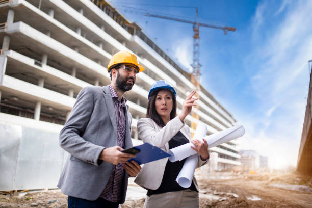 istock Multi-ethnic engineer workers with blueprint on the construction site stock photo 1221710312