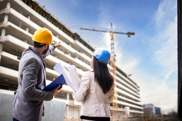 istock Multi-ethnic engineer workers with blueprint on the construction site stock photo 1221711037