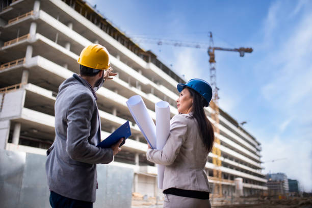 istock Multi-ethnic engineer workers with blueprint on the construction site stock photo 1221711064