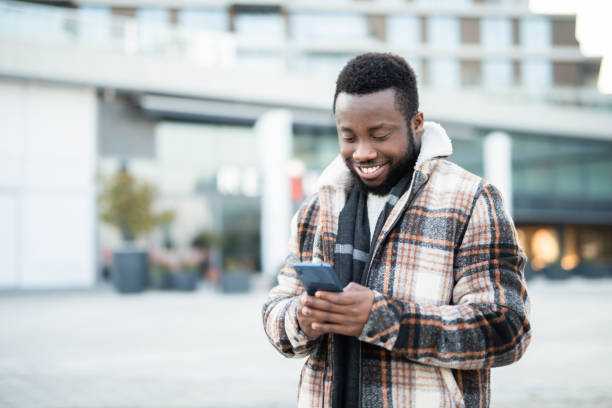 istock Happy young man reading an article on a phone. 1221712779
