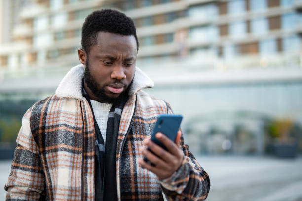 istock Young man reading a message on a phone. 1221712923