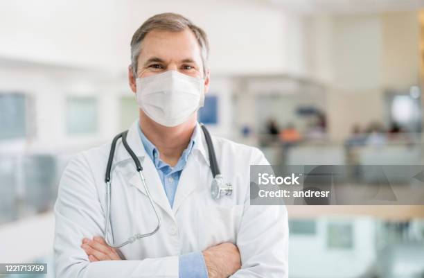 Happy Doctor Working Wearing A Facemask To Avoid Covid19 Stock Photo - Download Image Now