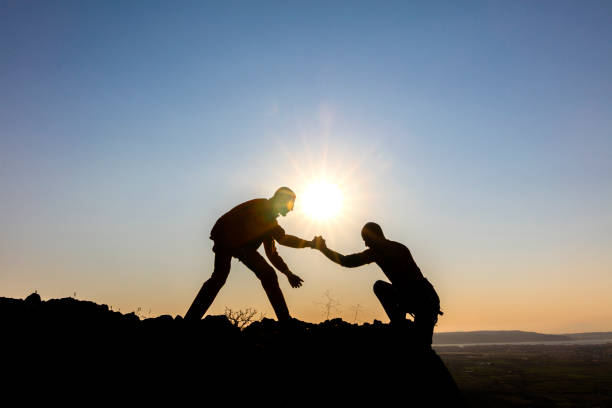 istock Mountaineer couple scramble up to mountain peak 1221714069