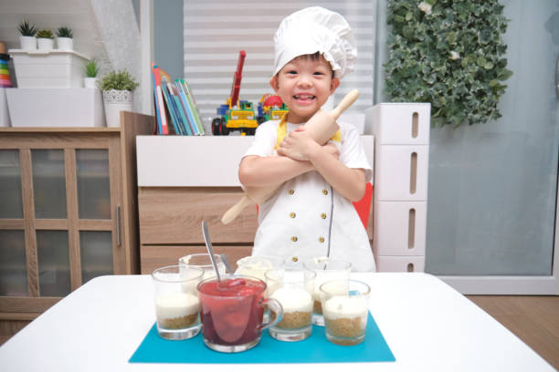 Cute smiling Asian 4 years old boy child with a rolling pin having fun cooking strawberry cake at home, Fun indoor activities for kindergarten concept Cute happy healthy smiling Asian 4 years old boy child with a rolling pin having fun cooking strawberry cake at home, Cooking with kids, Fun indoor activities for kindergarten concept food elementary student healthy eating schoolboy stock pictures, royalty-free photos & images