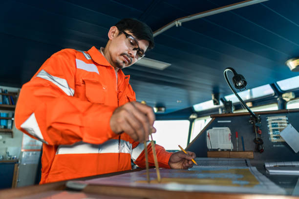 istock Filipino deck Officer on bridge of vessel or ship. He is plotting position on chart 1221719623