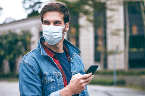 istock Man is wearing a surgical mask and sending a message to someone 1221719887