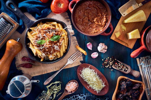 istock Penne with Bolognese sauce in serving size casserole with ingredients in rustic pots 1221720738