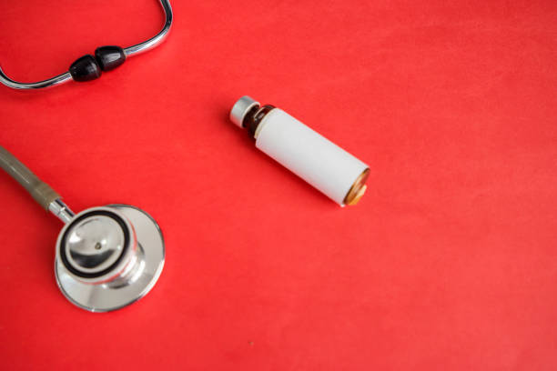 istock medical stethoscope and bottle with copy space isolated over red background 1221721881