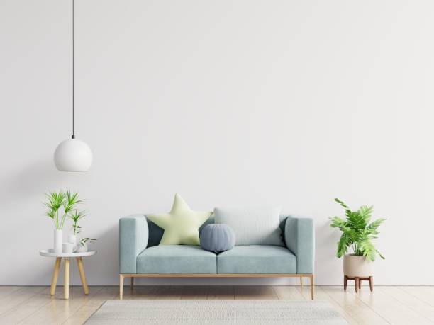 istock Empty living room with blue sofa, plants and table on empty white wall background. 1221722610