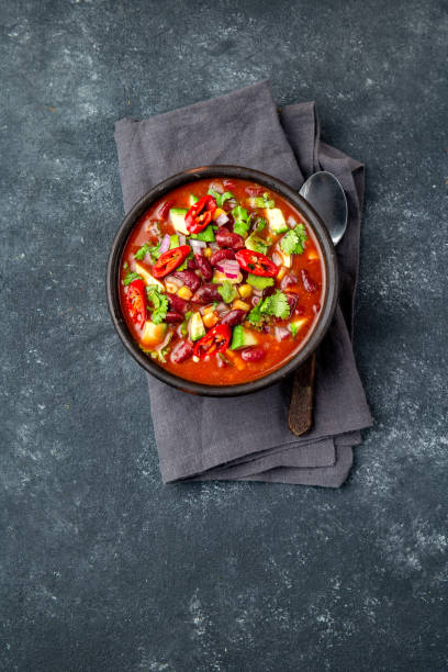 istock Mexican black bean tomato soup in clay bowl. Gray background 1221723443