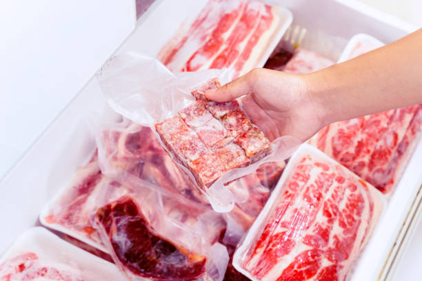 istock Closeup of hand picking a package of cube red meat 1221725361