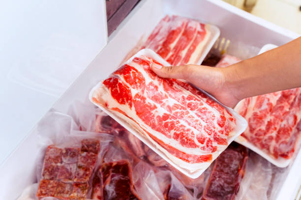 istock Closeup of human hand picking big chunk red meat 1221725366