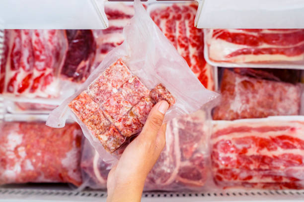 istock Top view of hand picking a pack of cube red beef 1221725394