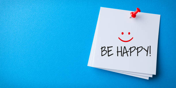 White Sticky Note With Be Happy And Red Push Pin On Blue Background