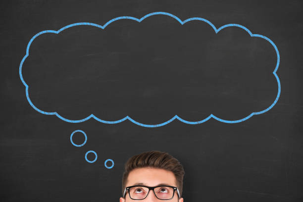 Business man standing next to thought bubble drawn on chalkboard