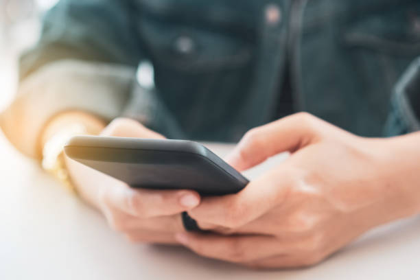 istock Womanhand using smartphone to do work business, social network, communication in public cafe work space area. 1221728719