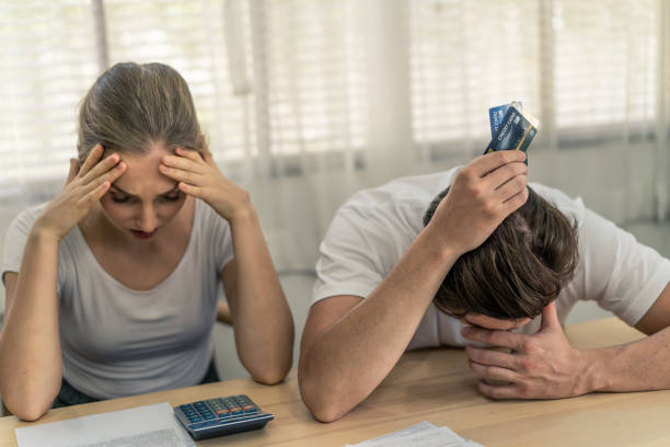 Stressed young Caucasian couples sitting with hand holding credit cards and look at bills worry about find money to pay credit card debt and all loan bills. They feel stressful. Financial problem. parejas jóvenes caucásicas estresadas sentadas con la mano sosteniendo tarjetas de crédito y miran las facturas se preocupan por encontrar dinero para pagar deudas con tarjetas de crédito y todas las facturas de préstamos. se sienten estresantes. prob