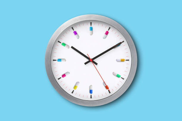 Wall clock with medicine capsules stock photo