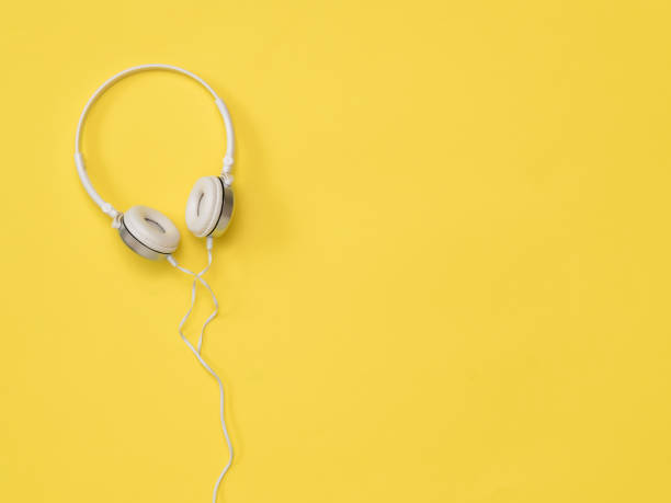 istock White headphones with a wire on a bright yellow background. 1221731583