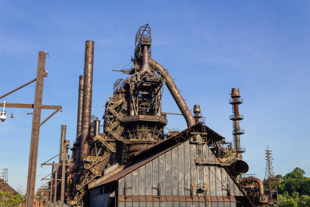 istock Massive industrial complex, abandoned and weathered furnaces and smokestacks before a deep blue sky 1221732420