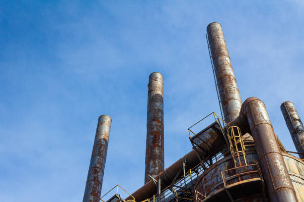 istock Tall, rusting smoke stacks silhouetted against a bright blue sky, abandoned industrial complex, copy space 1221732460