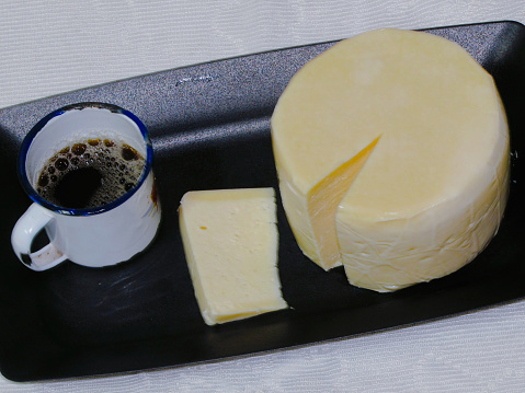 Black coffee in iron mug, a delicious cheese from Serro, traditional from Minas Gerais, Brazil.