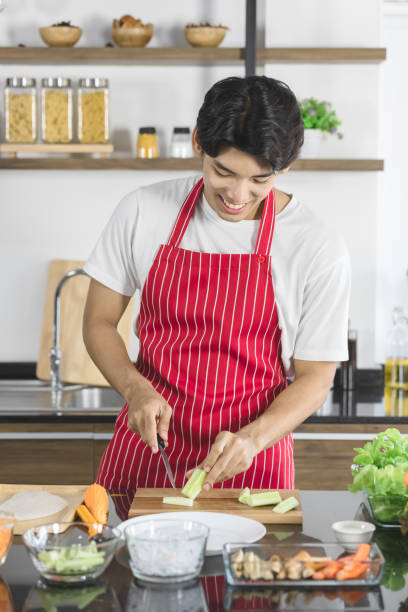 istock Asian man, he cutting cucumber into small pieces. 1221736067